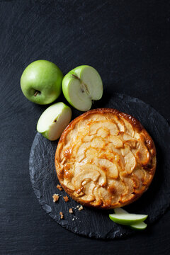 Apple cake and green apples on slate