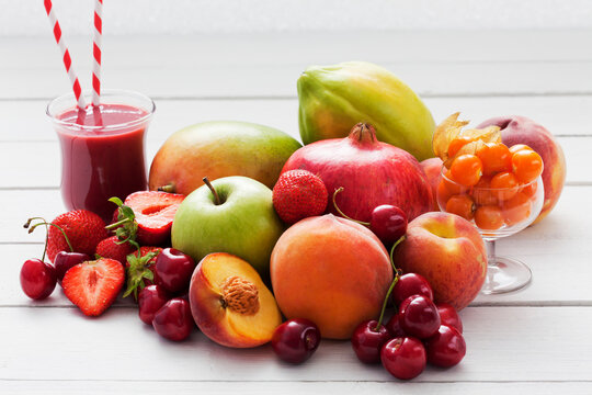 Different fruits and a glass of strawberry smoothie