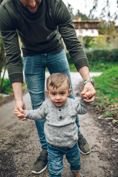 Father leading little boy on path