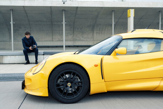 Person operating a futuristic yellow car with a robot