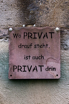 Humorous private property sign on a stone wall in Germany