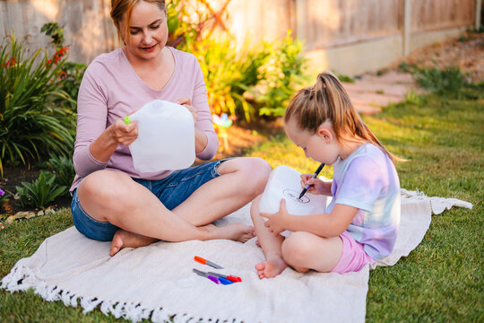 Mother and daughter recycle plastic bottles in the backyard