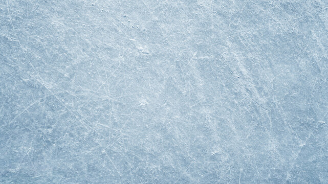 An ice surface as an ice rink with ice skates tracks. Winter sports texture. Poster with copy space.