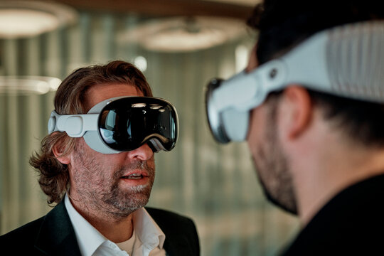 A businessman wears a virtual reality headset in a smart office