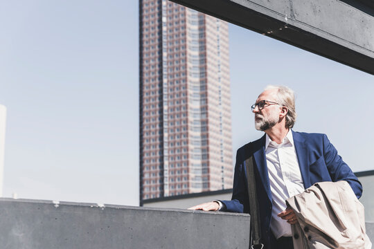 Serious mature businessman in the city looking around
