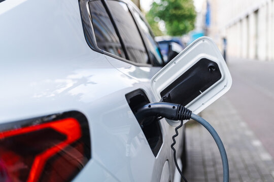 White Electric Car Charging at Open Rear Port