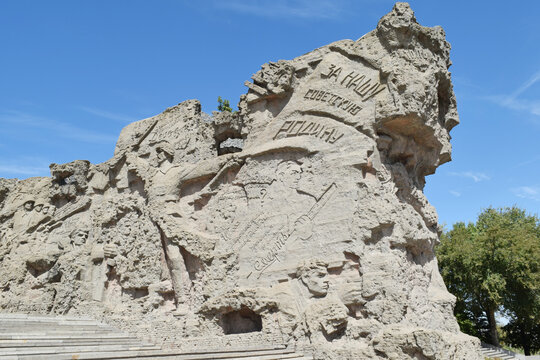 The monumental relief walls depicting battle scenes rise beneath The Motherland Calls statue at Mamayev Kurgan memorial complex in Volgograd on September 1, 2026.