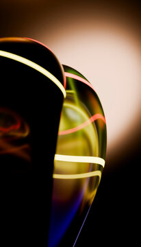 Abstract glass sculpture with glowing colorful light lines in studio