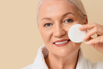 Healthy aging and skincare routine, mature woman using cotton pad for facial cleansing and beauty care in a spa or home bathroom environment © Pixel-Shot