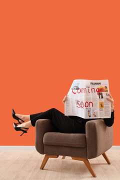 Coming soon announcement, marketing campaign and product launch concept, woman reading newspaper with red text in armchair against orange background