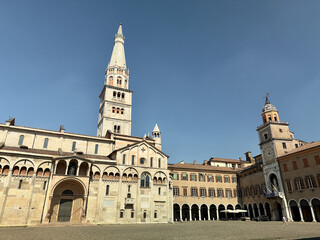 Fototapeta premium Modena Cathedral and Ghirlandina tower viewed from Piazza Grande on a bright sunny summer day, Emilia-Romagna, Italy. 