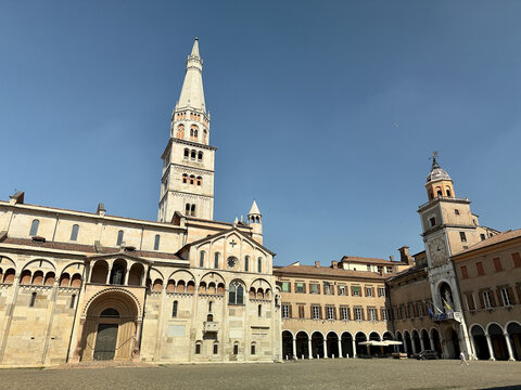 Modena Cathedral and Ghirlandina tower viewed from Piazza Grande on a bright sunny summer day, Emilia-Romagna, Italy.
