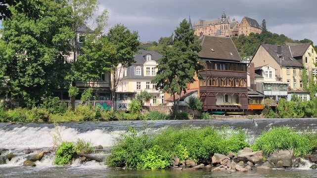 Scenic view of the historic city of Marburg, Germany, seen from the river. Urban architecture and the old town create a picturesque European cityscape.