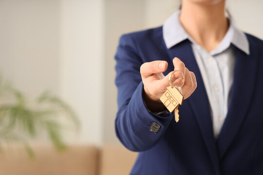 Female realtor with key to rented apartment on moving day, closeup