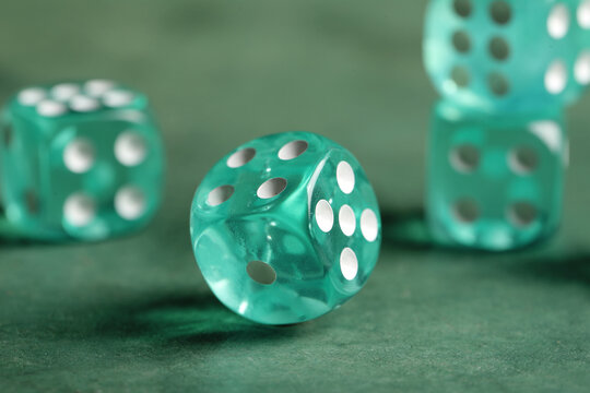 Turquoise game dices on green background