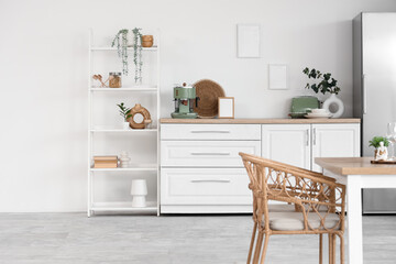 Interior of stylish kitchen with dining table, refrigerator and shelving unit