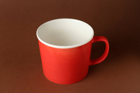 Red ceramic cup on brown background