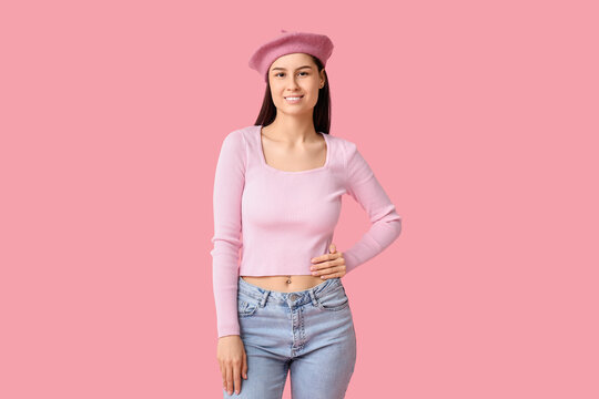 Beautiful young woman in stylish beret hat on pink background