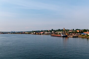 Obraz premium River recycling terminal with cargo barge and dock crane at organized metal recovery yard