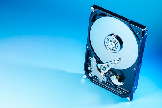 opened computer hard disk drive HDD internal components focusing on plattered disk and actuator read write head arm as a conceptual metaphor for cyber security big data cloud computing infrastructure