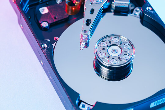 opened computer hard disk drive HDD internal components focusing on plattered disk and actuator read write head arm as a conceptual metaphor for cyber security big data cloud computing infrastructure