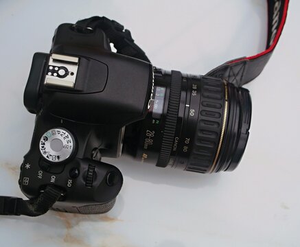 Canon EOS DSLR camera and lens on white surface