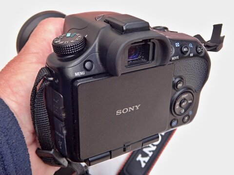 Hand holding Sony Alpha digital camera for photography