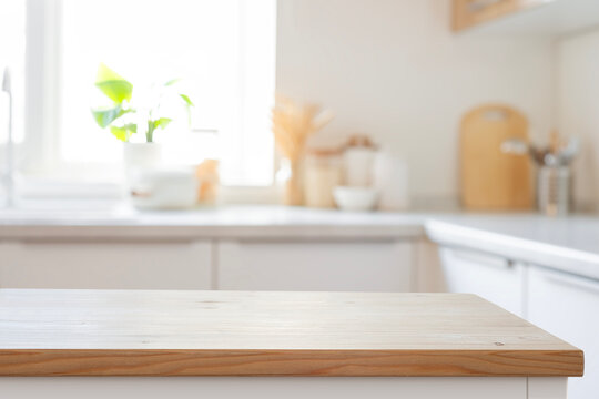 Wooden empty table as foreground with bright blurred kitchen interior background