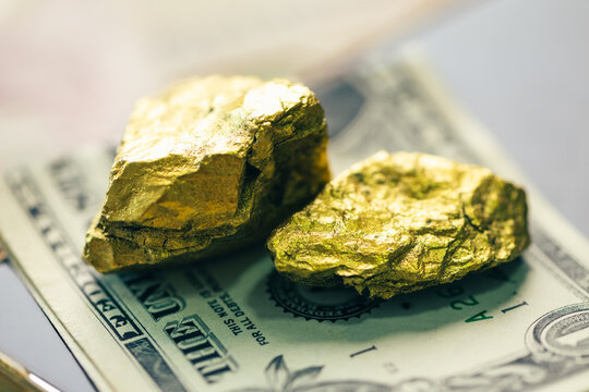 pure gold bullion bar 99.9 next to natural gold nuggets on a silver ore stone plate as a conceptual backdrop for global finance gold investment wealth safety haven banking economy and asset management