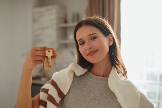 Young woman holding new house keys smiling