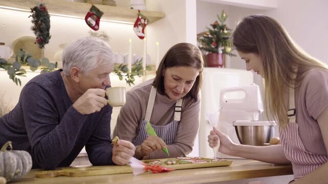 Family decorating Christmas gingerbread cookies together at home