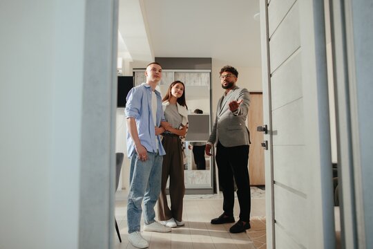 Real estate agent showing house to young couple