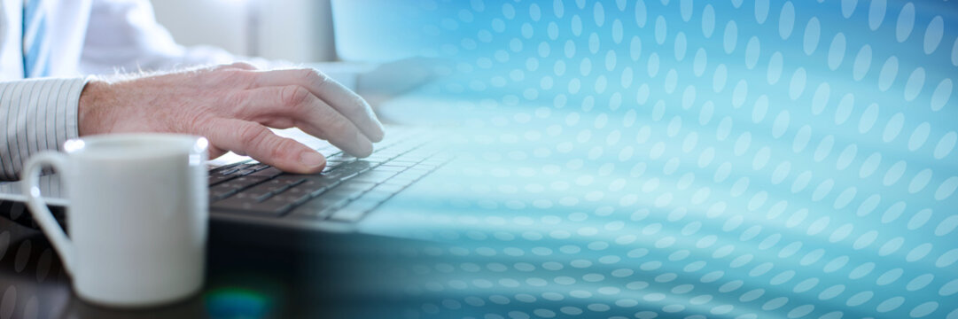 Businessman typing on a laptop; panoramic banner