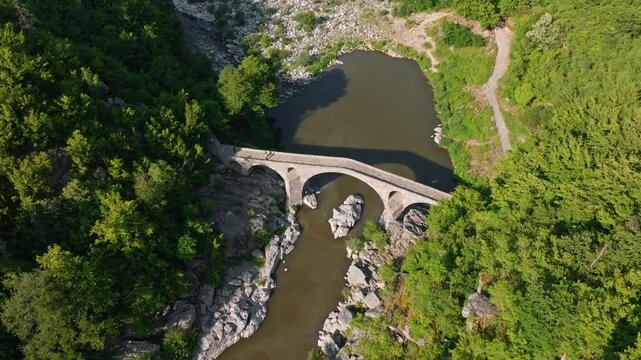 Aerial view Devils Bridge arch reflection water Arda river gorge green mountain forest Ottoman stone landmark Ardino Bulgaria travel tourism hiking adventure