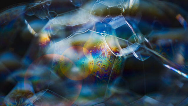 Iridescent soap bubble cluster showing abstract fluid patterns