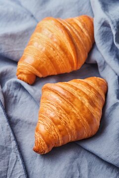 Freshly baked croissants on a blue tea towel cloth
