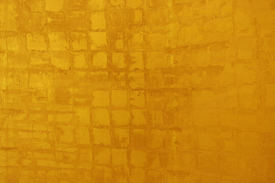 Abstract golden yellow painted texture background with subtle grid pattern and rustic brush strokes.