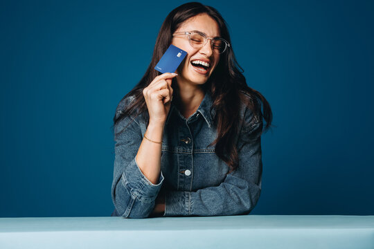 The joy of financial freedom: Woman laughter with credit card in studio