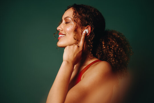Enjoying good audio with earbuds in studio portrait