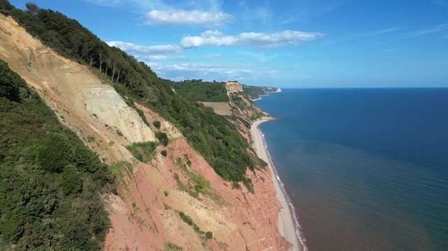 Sidmouth, Devon, England: DRONE VIEWS: 1. Red sandstone cliffs which form part of the Jurassic Coast; 2. A microlight plane approaches the camera. The coastline is a UNESCO World Heritage Site.