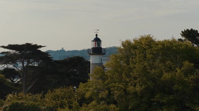 Drone view of Tristan Lighthouse surrounded by trees in Douarnenez, Brittany