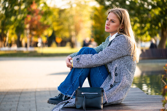 Businesswoman sitting in a public park, feeling disappointed and overwhelmed while dealing with anxiety, work problems and emotional stress.