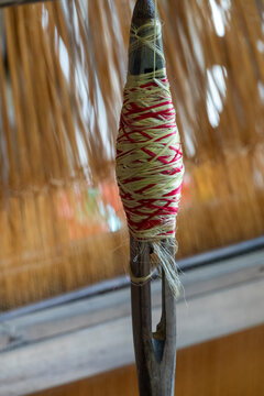 Bobbin wound with cream and pink thread on a traditional loom, Dhaka Division, Delduar, Bangladesh