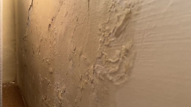 Panning shot of wall paint blistering and bubbling from moisture