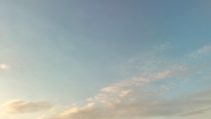 Obraz premium Pastel blue sky with softly illuminated clouds
