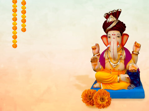 Traditional Lord Ganesha idol wearing a red turban with background