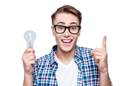 I know how it works! Close up portrait of cheerful, attractive high school man hold lamp in hands and raised up forefinger look at camera isolated on light blue gray background