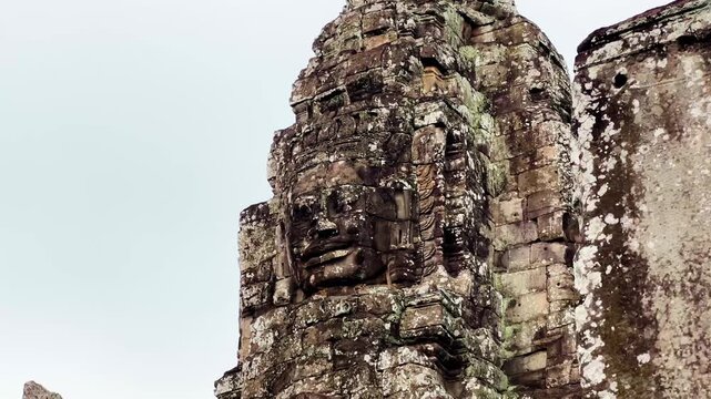 Close-up footage of the legendary stone face tower at Bayon Temple in Angkor Thom, Cambodia. The video highlights the iconic smiling face carved into weathered sandstone, showcasing the remarkable