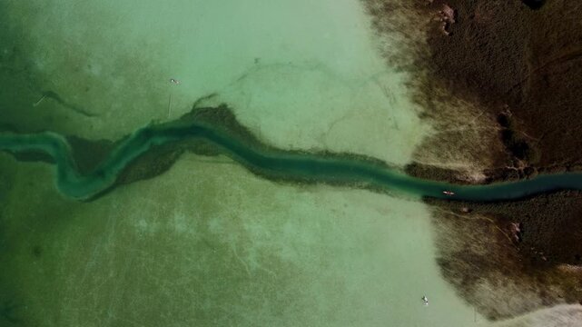Aerial Top Down View of a River Channel Meandering Through the Crystal Clear Waters of Lake Achensee, Austria