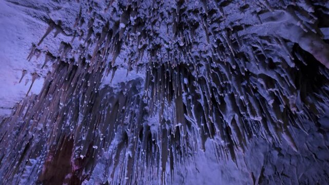 Blue icicles on a frozen cave ceiling